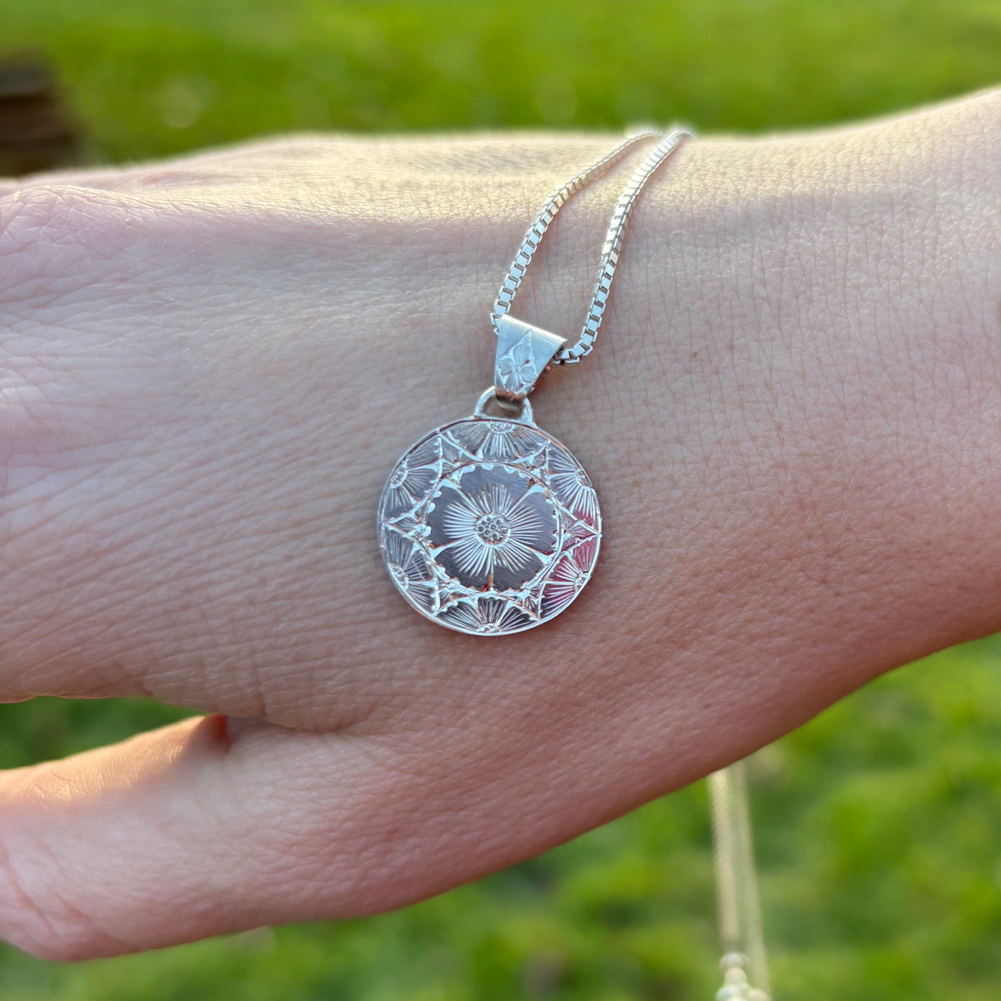 Silver pendant with hand engraved flowers
