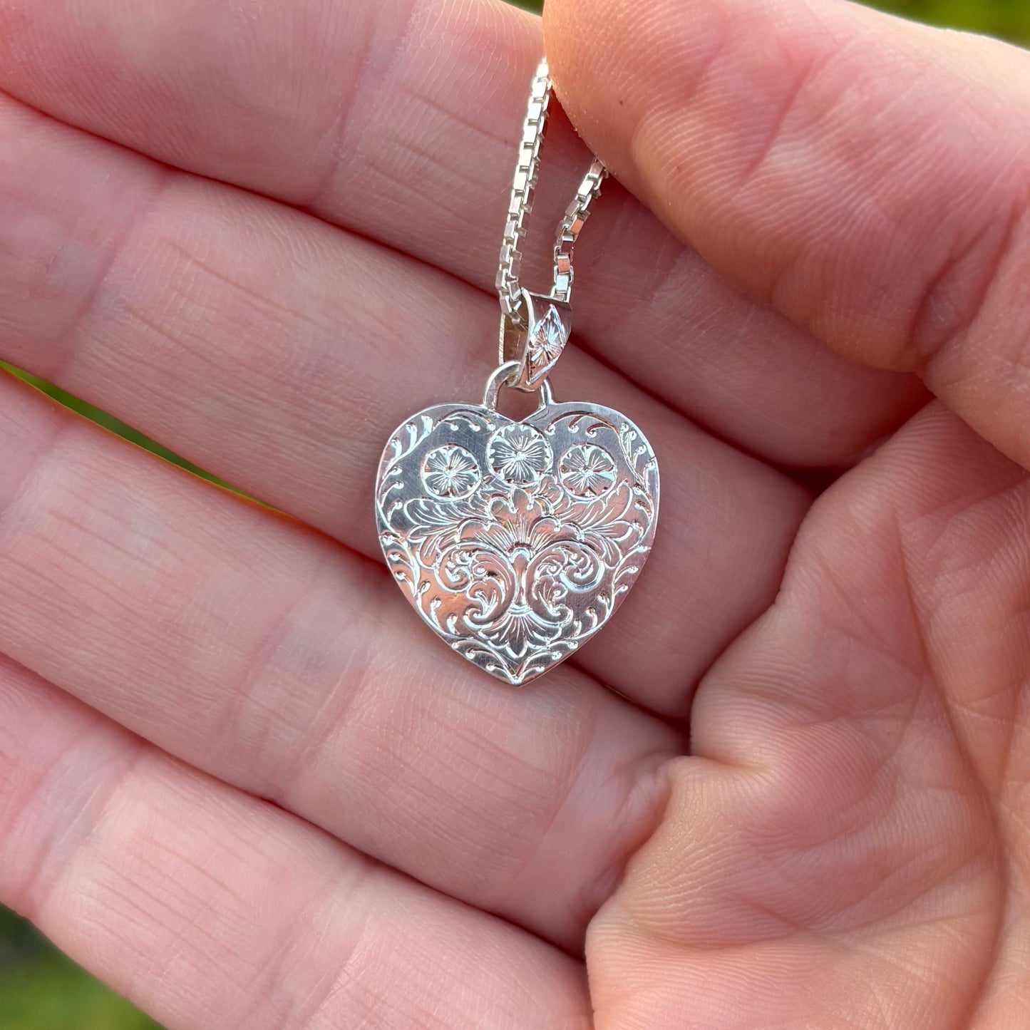 Silver heart pendant with hand engraved flowers