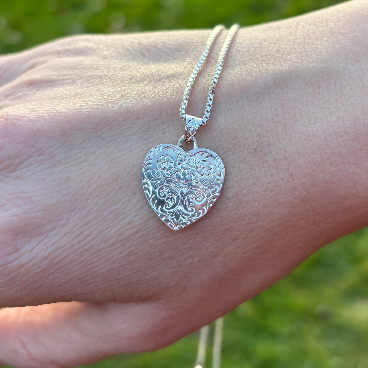 Silver heart pendant with hand engraved flowers
